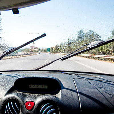 Imagem ilustra um para-brisa limpando o vidro do carro.