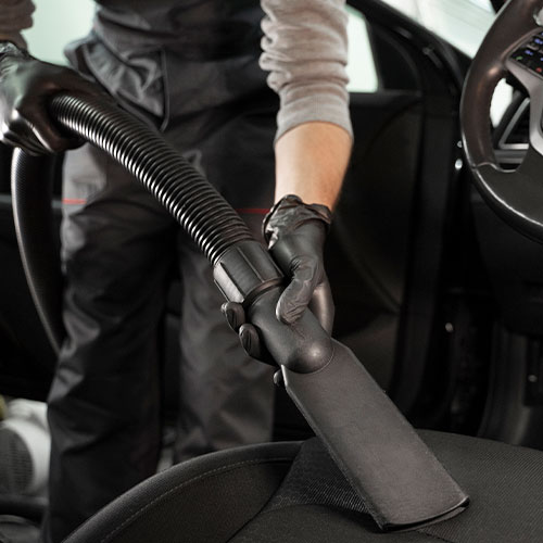 a imagem ilustra uma pessoa aspirando um carro