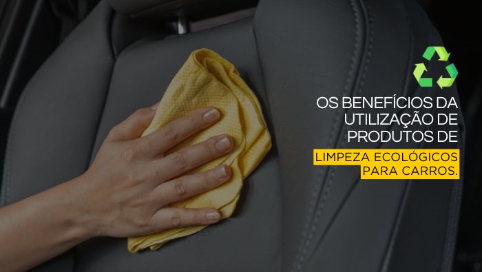 Mão segurando um pano amarelo limpando o estofado de um carro, simbolizando cuidados com a limpeza e conservação interna do veículo.